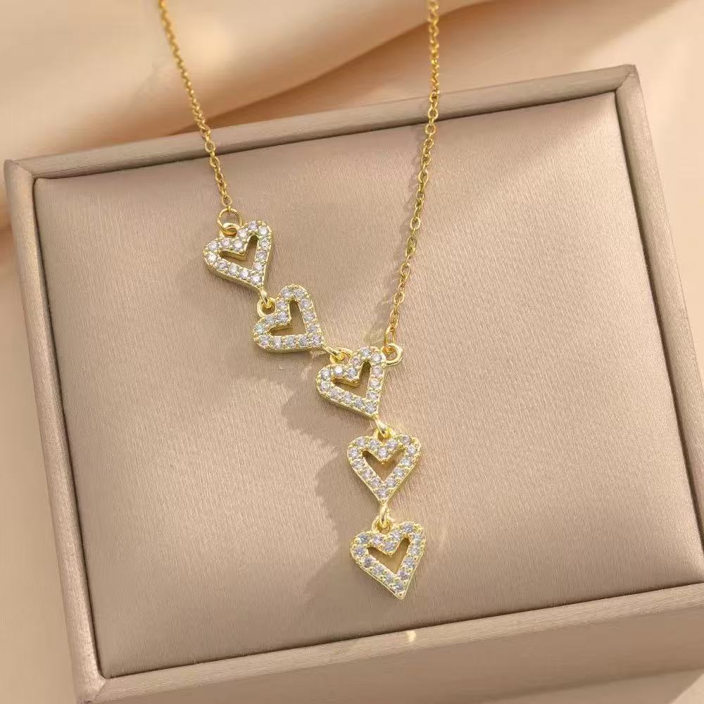 A gold-tone necklace with a cascade of sparkling heart-shaped pendants.